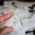 Scontrino della farmacia su un tavolo, con evidenza delle spese mediche da scaricare.